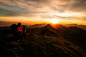 Wanderer im Sonnenaufgang auf den Berggipfeln der Karawanken im Rosental in Kärnten.